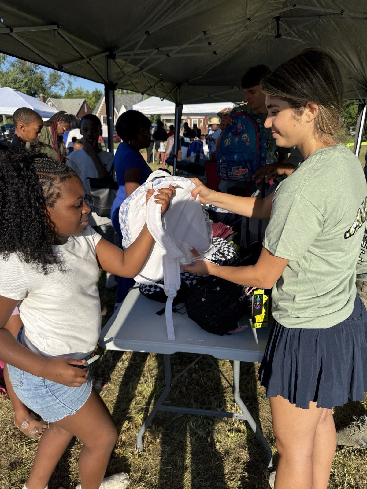 Volunteer handing out supplies to a student